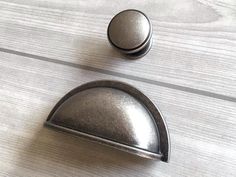 two metal knobs on a wooden surface