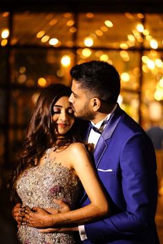 a man in a blue suit and woman in a gold dress