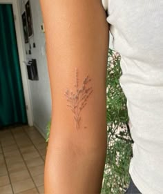 a woman's arm with a tattoo on it that has flowers in the middle