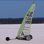 a person on a small sailboat in the middle of an open field with water