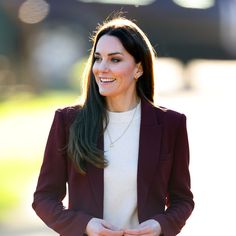 a woman wearing a maroon jacket and white sweater