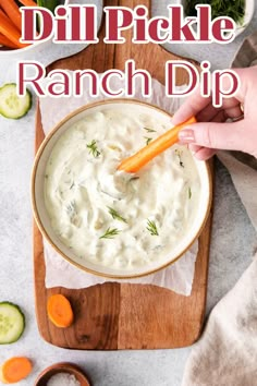 a person dipping ranch dip into a bowl with carrots and cucumbers in the background