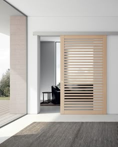 an open door with wooden slats in the middle of a living room next to a couch