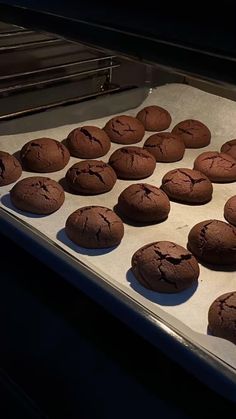 chocolate cookies are lined up on a baking sheet in the oven, ready to be baked