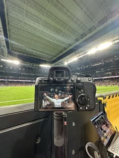 a camera is sitting on top of a desk in front of a laptop and other items