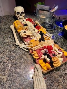 a skeleton sitting on top of a table covered in food