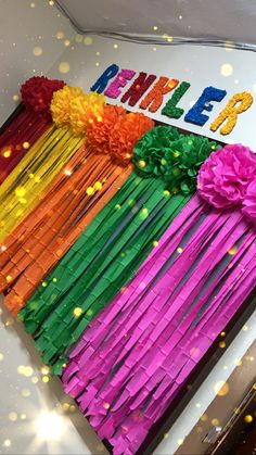 there is a birthday cake decorated with colorful streamers and flowers on the top, surrounded by confetti