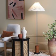 a living room with two vases and a lamp on the table next to it