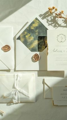 the wedding stationery is laid out on top of each other, including an envelope and two wax stamp stamps