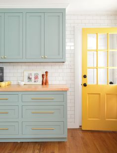 a kitchen with blue cabinets and yellow doors