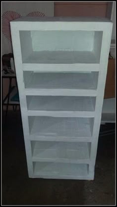 an empty white book shelf in a room