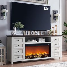 an entertainment center with a fireplace in the middle and a large screen on the wall