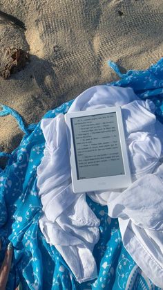 an open book sitting on top of a blue blanket