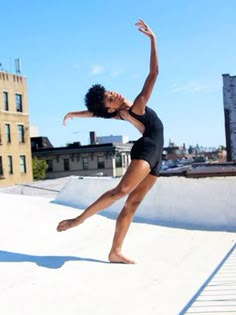 a woman in a black leotard is doing a trick on a skateboard