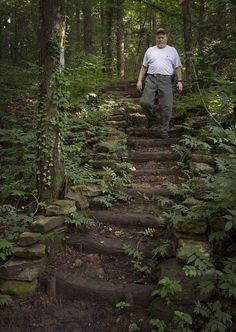 a man walking up some steps in the woods