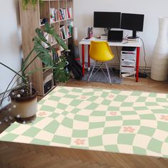 a room with a rug, computer desk and bookshelf