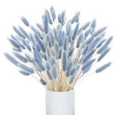 a white vase filled with lots of blue feathers