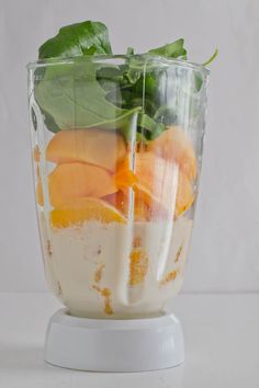 a blender filled with fruit and vegetables on top of a table