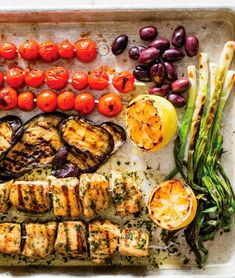 grilled chicken, tomatoes, asparagus and other vegetables on a tray