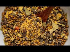 a bowl filled with lots of different types of food and a wooden spoon in it