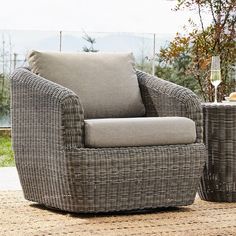 a wicker chair sitting on top of a rug next to a table