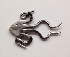 a metal object that is shaped like a mouse with long claws on it's back end