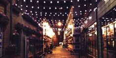 an alley way with lights strung from the ceiling