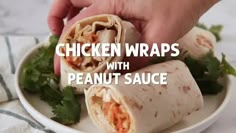 chicken wraps with peanut sauce on a white plate being held by a person's hand