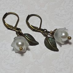 LILY OF THE VALLEY EARRINGS ▪️▪️▪️▪️▪️▪️▪️️▪️▪️▪️▪️▪️▪️ These dainty flower earrings are made with cute white Lucite flowers and elegant white glass pearls. An individual antique bronze leaf and lever back hooks finish them. They are very light weight so easy on the ears and perfect for everyday wear yet pretty enough for special occasions, bridesmaids or as a cute gift.  💜MATERIALS *Antique Bronze Findings *Lucite Flowers *White Glass Pearls   💜DIMENSIONS *1.8cm drop ▪️▪️▪️▪️▪️▪️▪️️▪️▪️▪️▪️▪️ Vintage White Flower Drop Earrings, Vintage White Dangle Flower Earrings, White Flower Earrings, Red Flower Earrings, White Flower Earring, White Pearl Earrings, Pink Gift Box, White Pearl Earring, Bronze Earrings