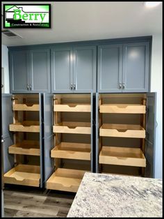 empty shelves in a kitchen with blue cabinets and marble counter tops on the side wall