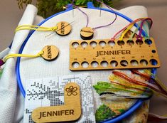 wooden name tags are attached to the back of a cross - stitch project with thread