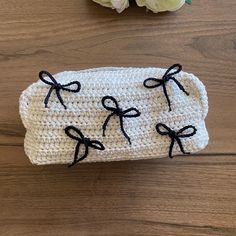 a crocheted case with black bows on it