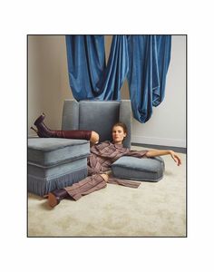 a woman laying on the floor in front of a couch with her legs spread out