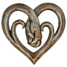 a wooden heart shaped like a gargoyle with two hands holding it's face