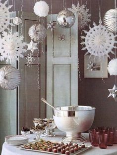 an assortment of christmas decorations hanging from the ceiling and in front of a bowl on a table