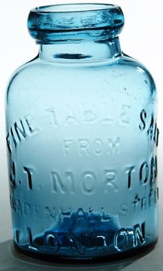 a blue glass jar with writing on it