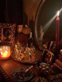 a table topped with candles and other items on top of a wooden table next to a mirror