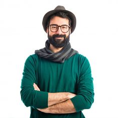 a man with glasses and a beard wearing a green sweater is standing with his arms crossed