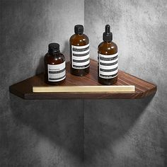 three bottles are sitting on a wooden shelf