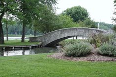 a stone bridge over a river in a park