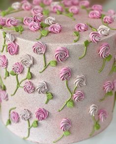 a pink and green decorated cake sitting on top of a table