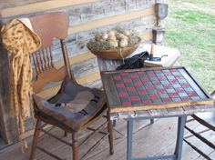 two chairs and a table with some food on top of it in front of a wooden wall