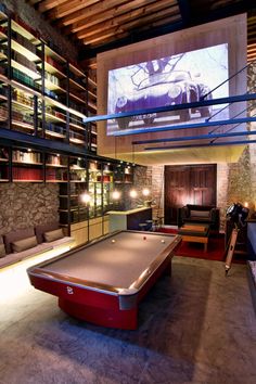 a pool table in the middle of a room with shelves full of books and furniture