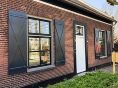 a brick building with black shutters and windows