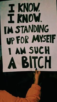 a person holding up a sign that says i know i know i'm standing up for my self