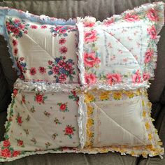 three pillows with flowers on them are sitting on a couch in front of a pillow