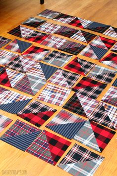 the floor is made up of many different plaid fabric pieces, including one red and black patchwork