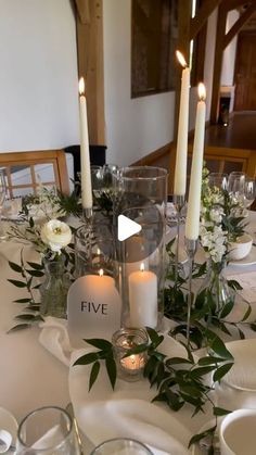 the table is set with white flowers and candles