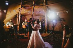 a bride and groom are dancing in the tent at their wedding reception with confetti falling all around them