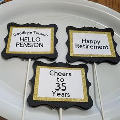 three black and gold birthday cake pops on a white plate with the words goodbye tension, hello pension, cheers to 35 years